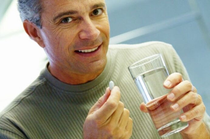 Un hombre toma una pastilla para tratar la prostatitis.